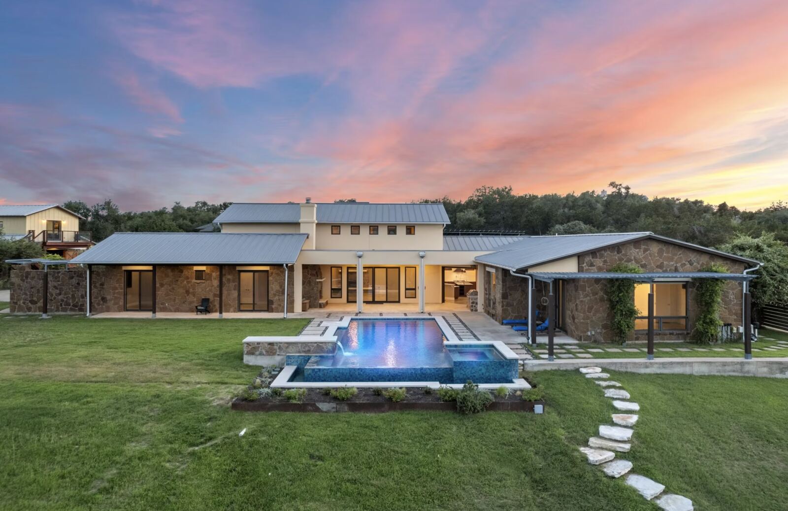 Hill-country home with pool at twilight